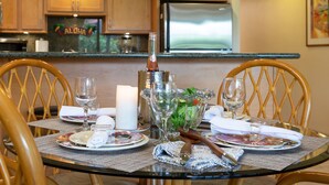A dining table set with plates, glasses, and a centerpiece.