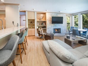 A modern living room with a fireplace, a bar area, and a seating arrangement. - Gateway Plaza R4 2 Bedroom Condo by RedAwning (Vail)
