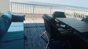 Ein Balkon mit Blick auf Strand und Meer.