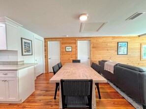 A compact living space with a dining table, chairs, a sofa, and a kitchenette.
