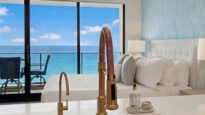 A modern kitchen with a stainless steel sink, gold faucets, and a view of the ocean. - ❤️ Renovated 8th Floor Studio at The Mahana!! ❤️ (Lahaina)