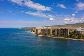 Ein Küstenhotel mit mehreren Gebäuden, einem Strand und freiem Blick auf den Ozean.