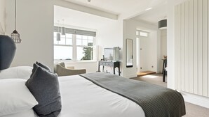 Un dormitorio moderno con una cama grande, un escritorio y vistas al exterior.