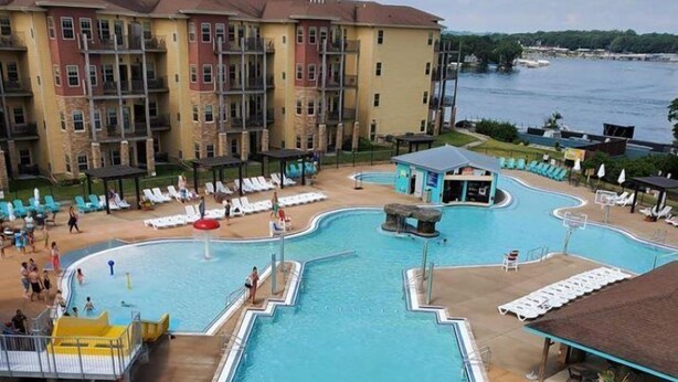 A pool area with slides and a view of a building with balconies.