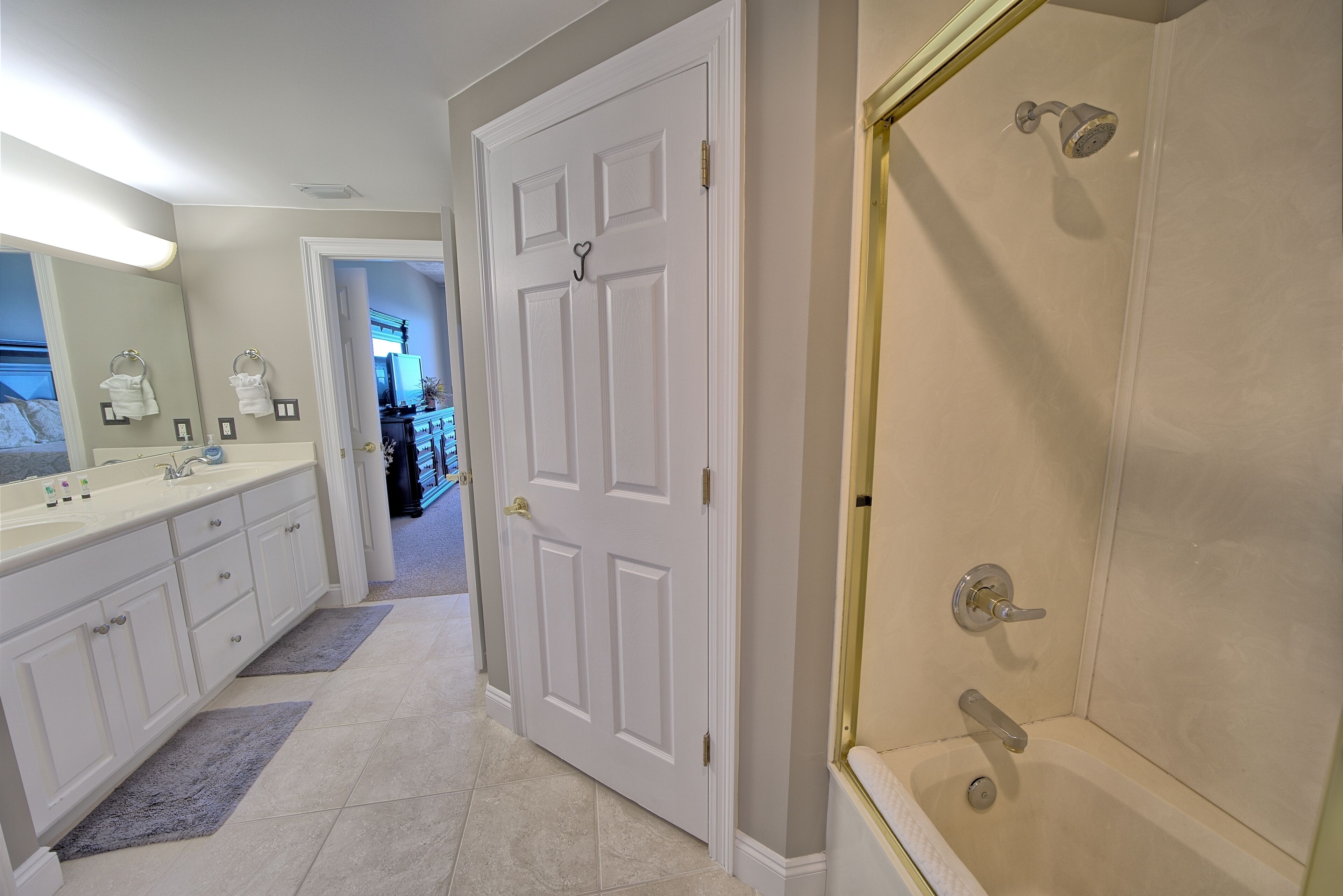 A modern bathroom with a walk-in shower, a double sink vanity, and a large mirror.
