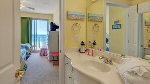 A hotel room with a large window, a balcony, a double sink, and a mirror. - Oceanfront Condo with Spacious Balcony - Unit 0306 by RedAwning (Panama City Beach)