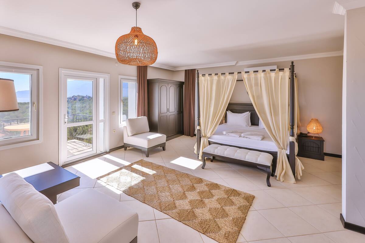 A bedroom with a bed, a sofa, a chair, a wardrobe, and a balcony.