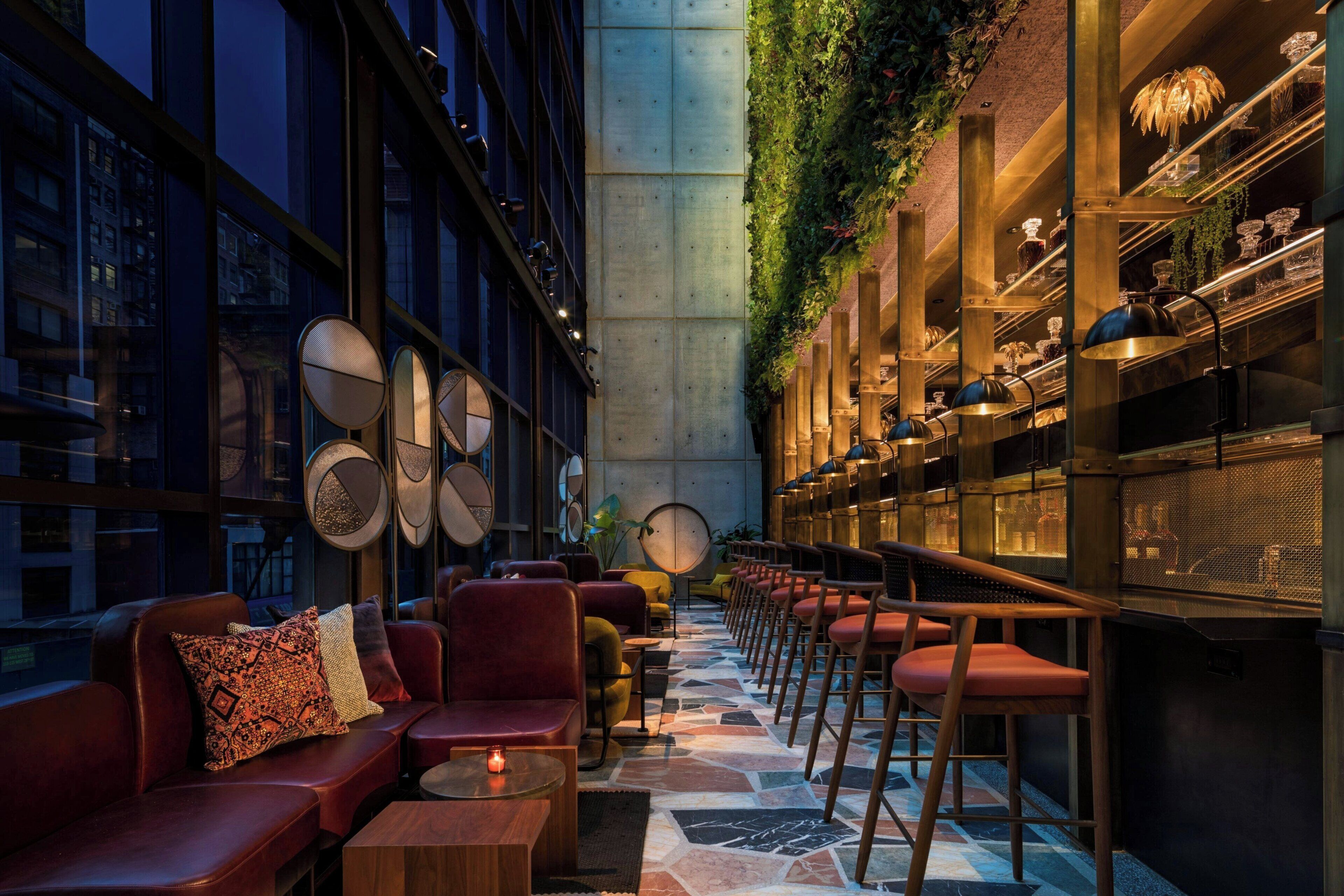 Een modern interieur met een bar, zitplaatsen en uitzicht op de stad.