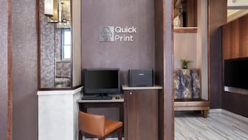 Ein Quick Print Druckstation mit Computer, Stuhl und Flachbildschirm.