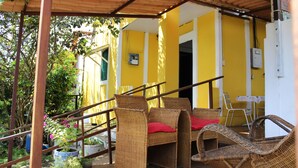 A covered outdoor area with wicker furniture, a staircase, and potted plants. - Pousada Água Viva (Fernando de Noronha)
