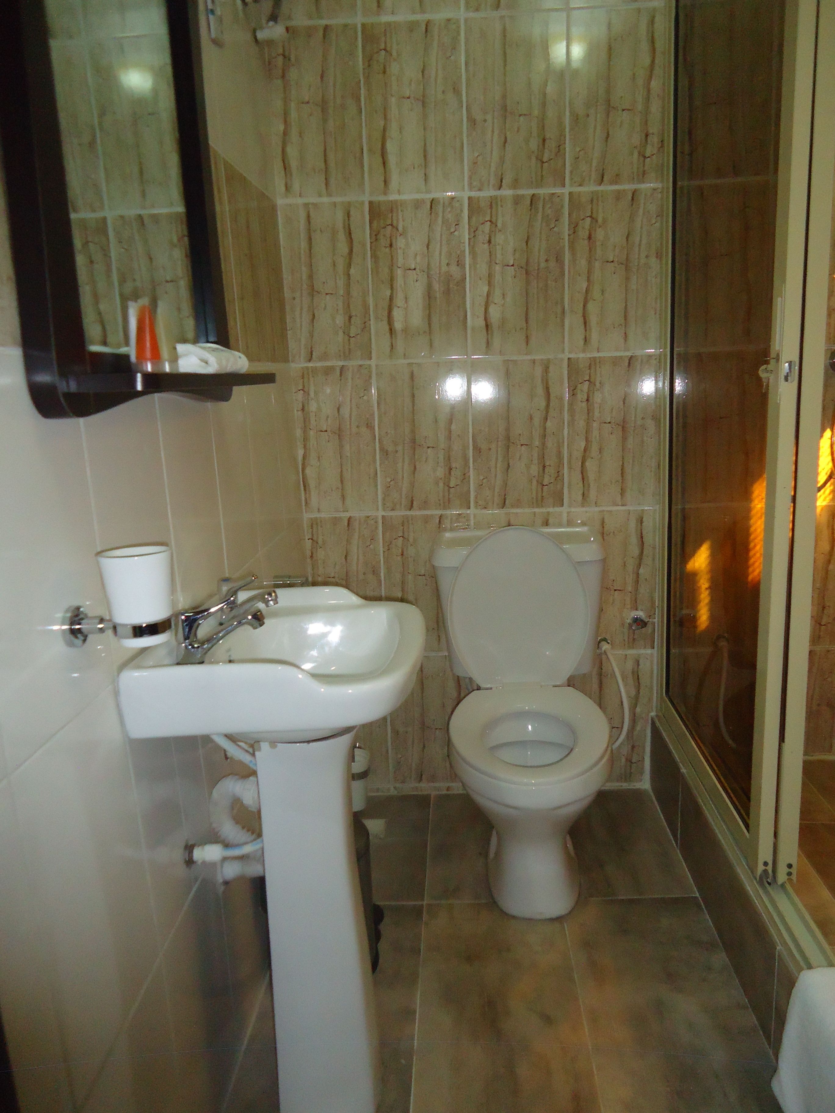 A bathroom with a sink, toilet, and shower.