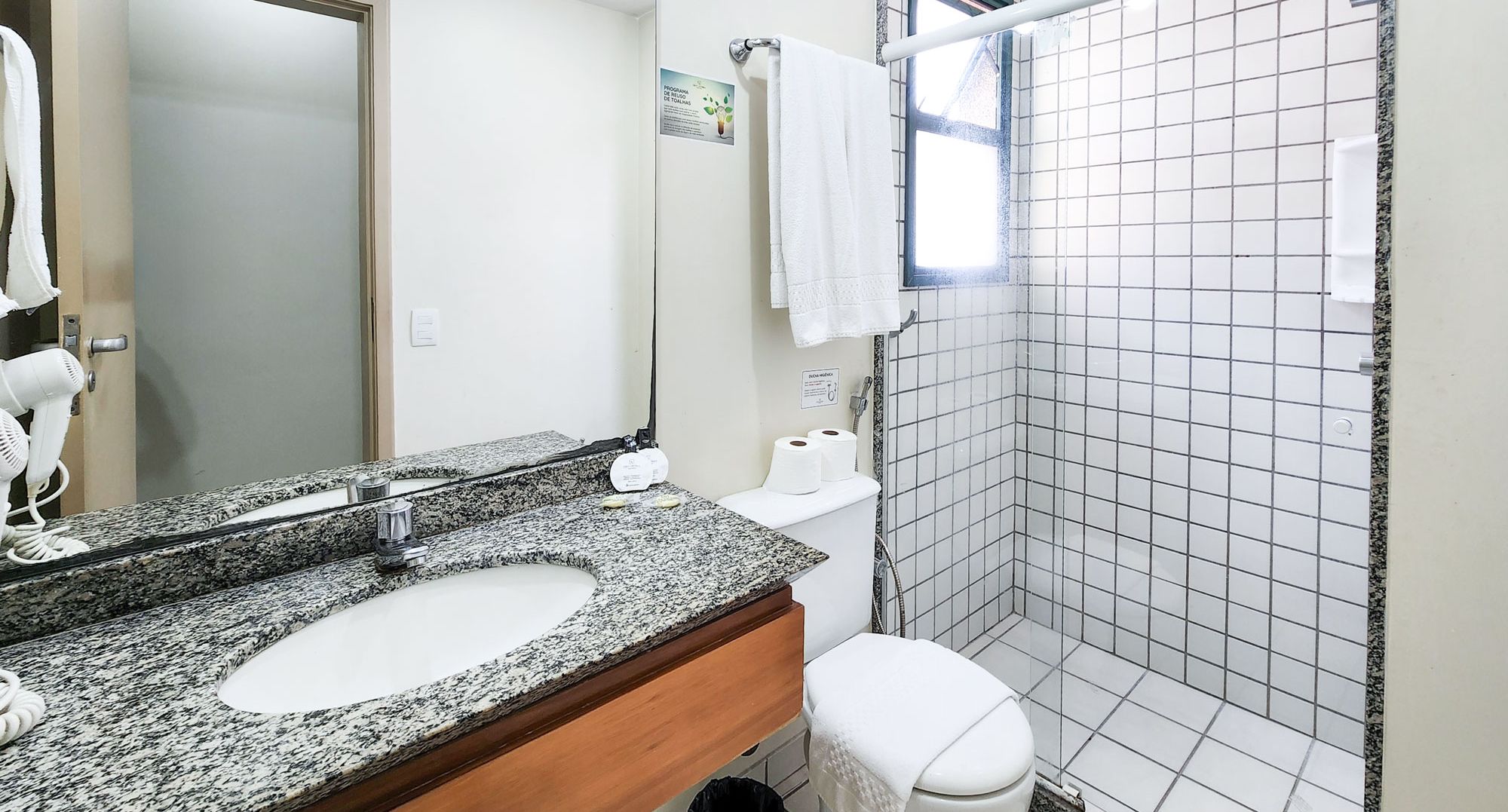 Un baño con dos lavamanos, un espejo, un inodoro y una zona de ducha.