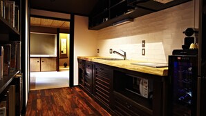 A modern kitchen with a wooden countertop, dark cabinetry, and a built-in wine cooler. - Kyoto Tradition With Modern Luxury, Family Friendly in Excellent Location (Kyoto)