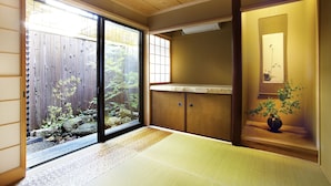 A traditional Japanese room with tatami flooring, sliding doors, a wooden ceiling, and a view of a garden. - Kyoto Tradition With Modern Luxury, Family Friendly in Excellent Location (Kyoto)