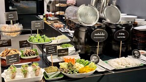 A buffet with various dishes including grilled pork, spicy sausage, and green chili dip. - Hug Nimman Hotel (Chiang Mai)