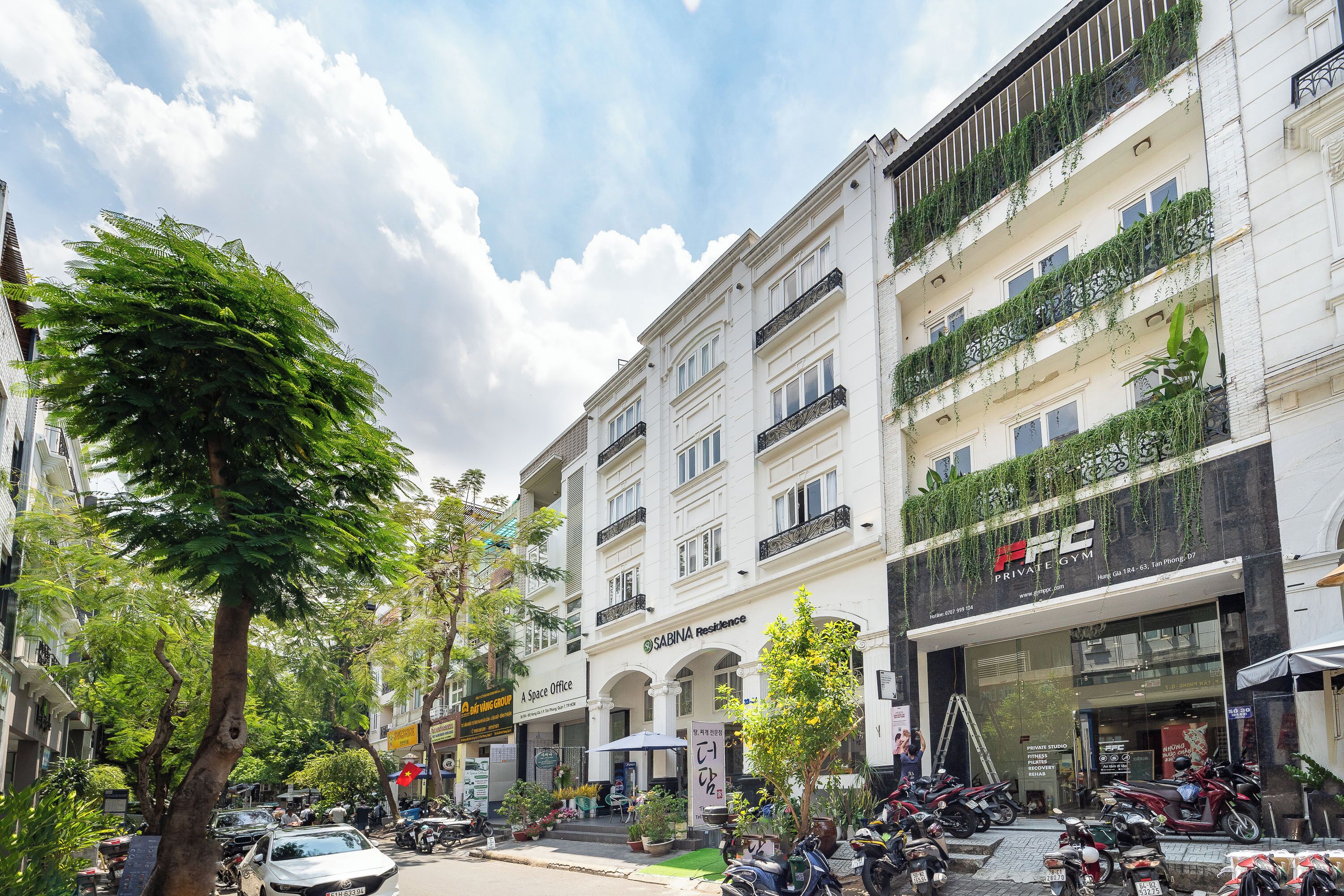A multi-story building with a gym on the ground floor, a cafe on the second floor, and a private studio on the third floor.