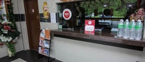 A reception area with a counter, a door, and a poster.