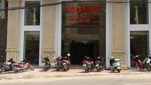 A hotel with a prominent sign, multiple parked scooters, and a clean facade. - Hoang Giang Hotel (Hai Phong)