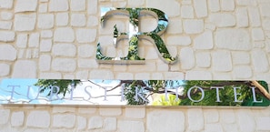 A sign for 'TRISTEK HOTEL' with a large 'R' and a reflective surface. - Er Turistik Hotel (Dikili)