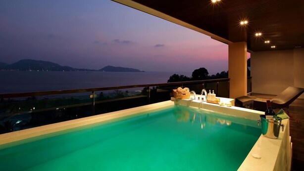 A rooftop infinity pool with a view of the sea at dusk. - Privilege Panoramic Sea View (Patong)