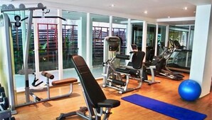 A gym with exercise equipment, a blue mat, and a large exercise ball. - Privilege Panoramic Sea View (Patong)