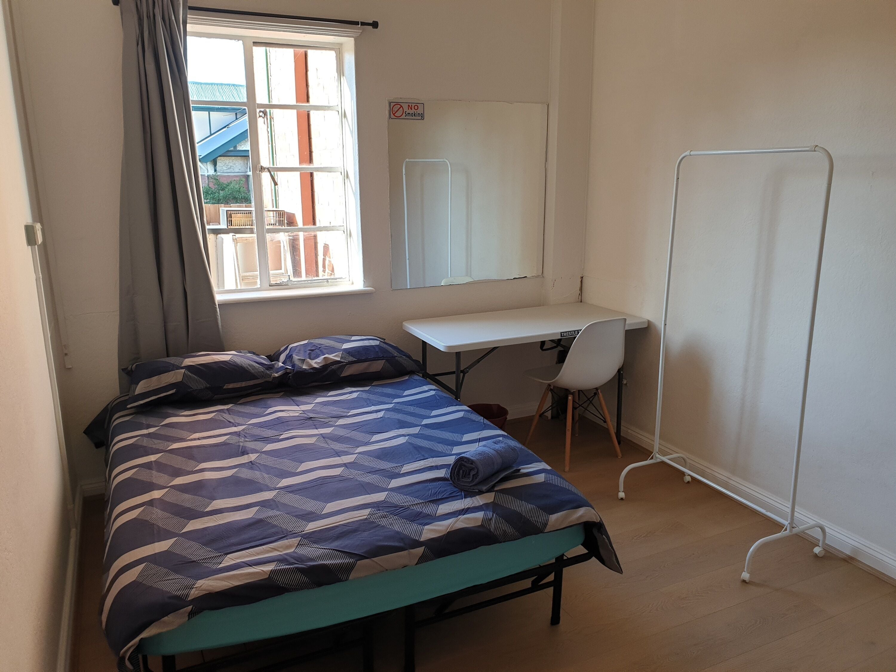 Ein Schlafsaalzimmer mit einem Bett, einem Schreibtisch und einem Stuhl.