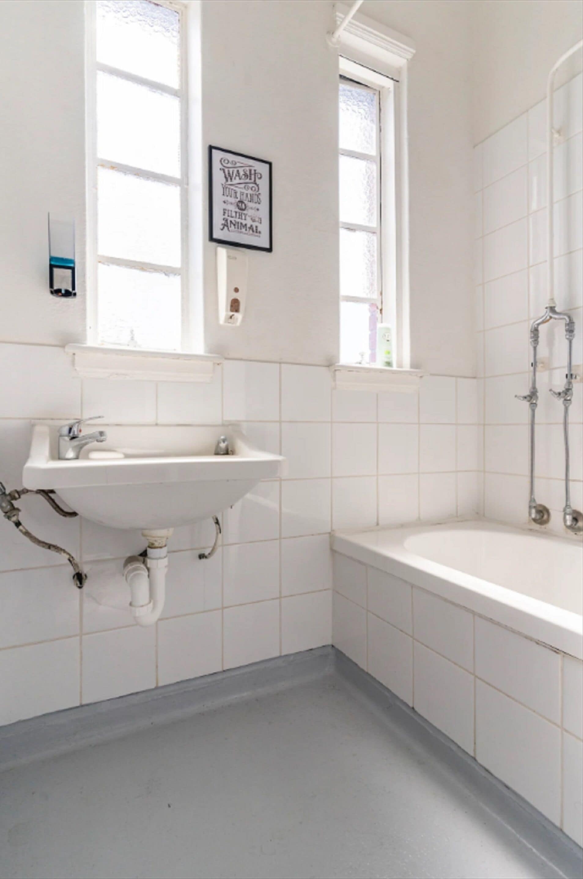Un baño con lavamanos, ventana y ducha.