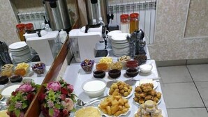 A buffet table with various food items and condiments. - Altamira (Karakol)
