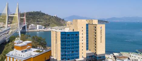 A hotel with a modern design, located near a bridge and waterfront.