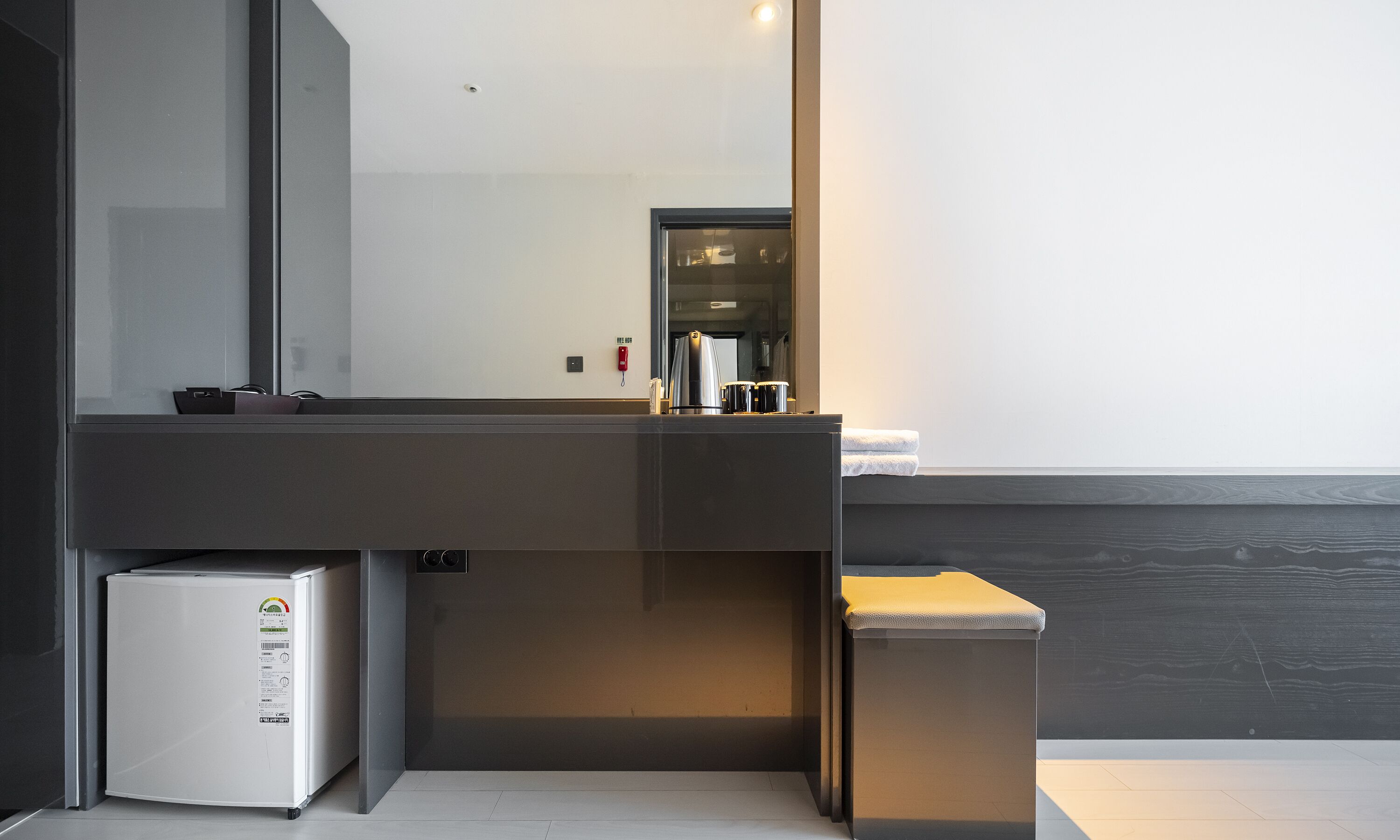 A modern bathroom with a large mirror, a sink, and a coffee machine.
