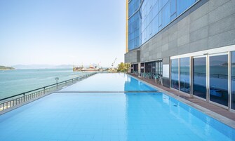 Una piscina al aire libre, sillones reclinables de piscina