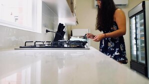 A kitchen with a gas stove, a person cooking, and a refrigerator. - Landing Pads Brunswick - Hostel (Brunswick)