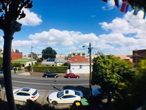 A street view with cars parked on the side, buildings in the background, and a clear sky. - Landing Pads Brunswick - Hostel (Brunswick)