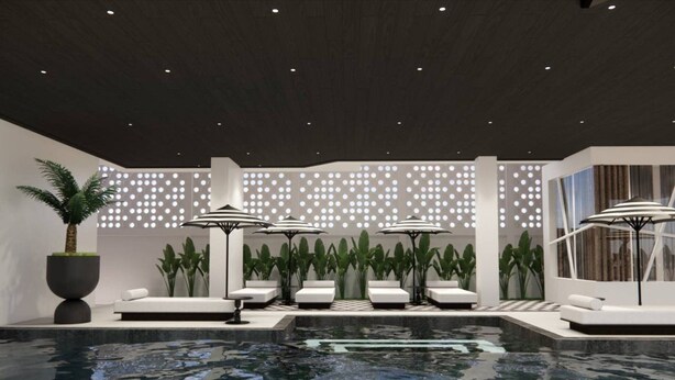 A modern indoor pool area with lounge chairs and umbrellas, surrounded by potted plants and a patterned wall. - Floral Hotel Chaweng Koh Samui (Koh Samui)
