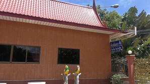 A building with a red tiled roof and a sign indicating it is the Memory Hotel. There are two parrots perched on a tree-like structure in front of the building. - Reurn Thai Resort Ratchaburi (Damnoen Saduak)