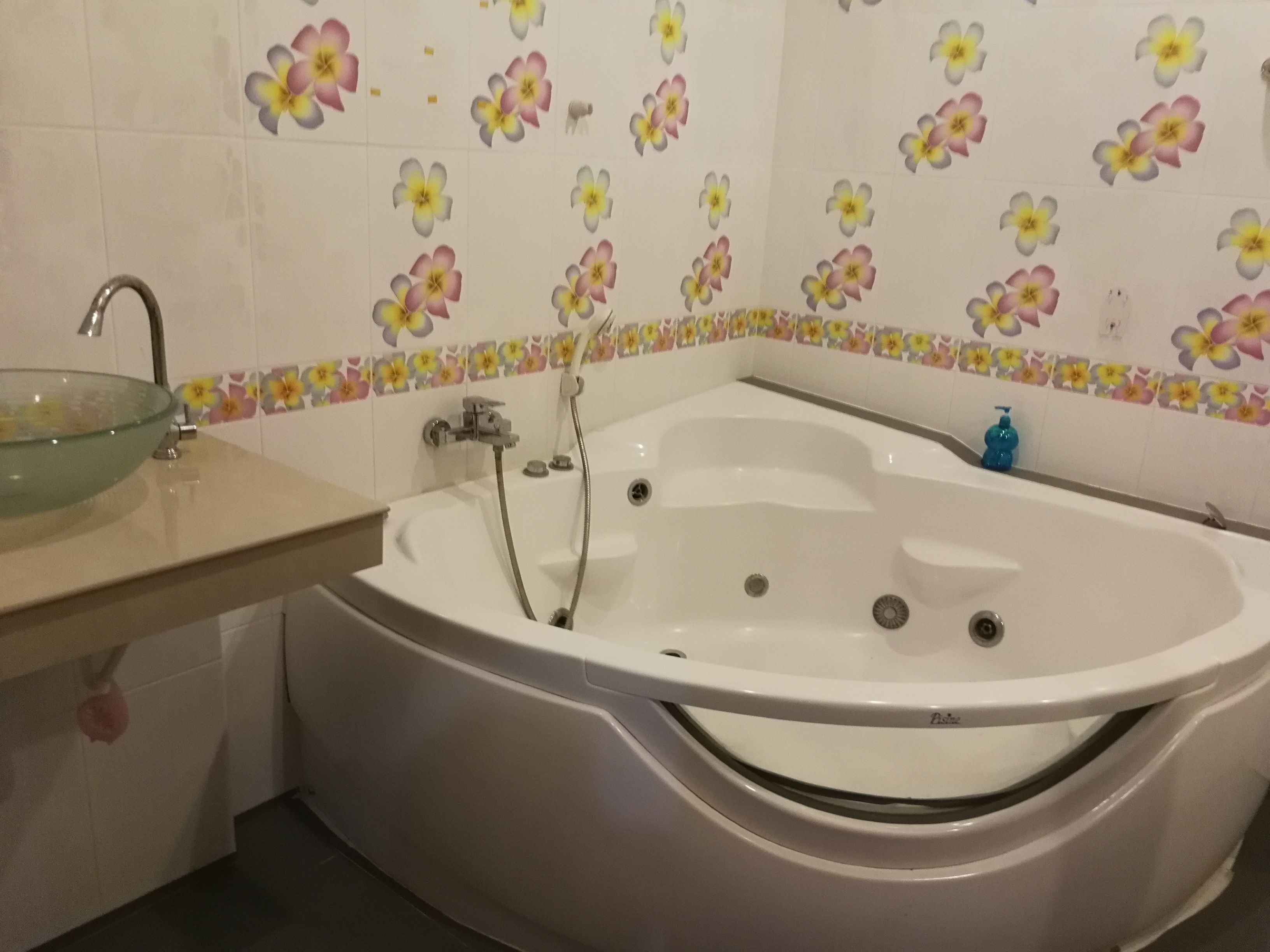 A bathroom with a freestanding bathtub, a glass basin, and a showerhead.