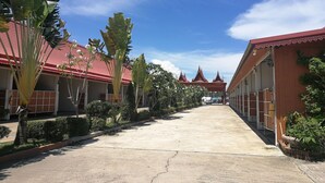 A pathway leading to a building with a traditional red roof and multiple rooms. - Reurn Thai Resort Ratchaburi (Damnoen Saduak)