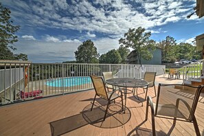 Une terrasse extérieure avec une piscine, des chaises et une table.