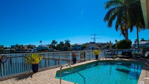 Piscina com vista para o porto de iates e edifícios ao fundo.