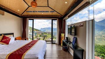 Una habitación con vistas panorámicas, que incluye una cama grande, un escritorio y un televisor.