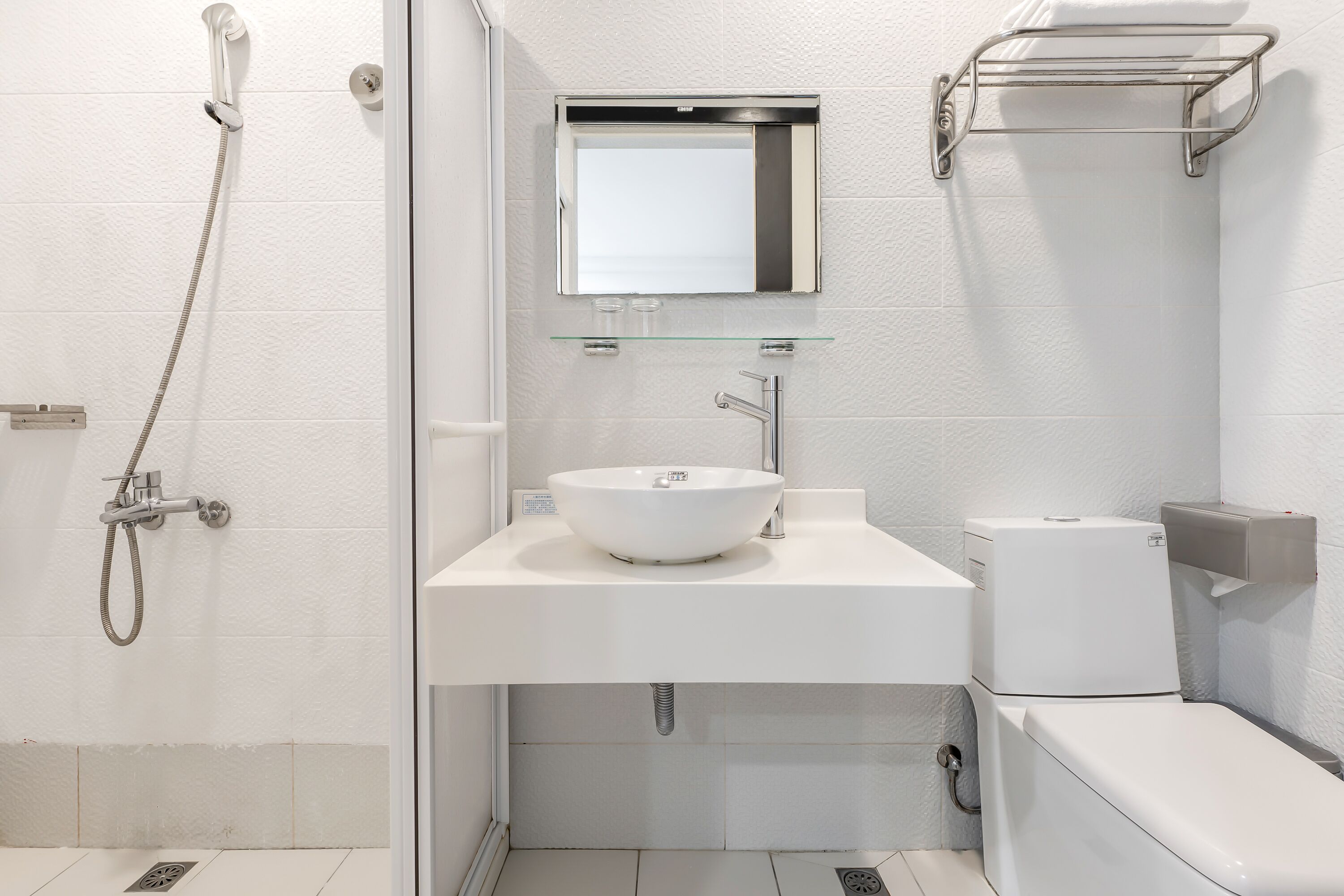 A modern bathroom with a shower, sink, and toilet.