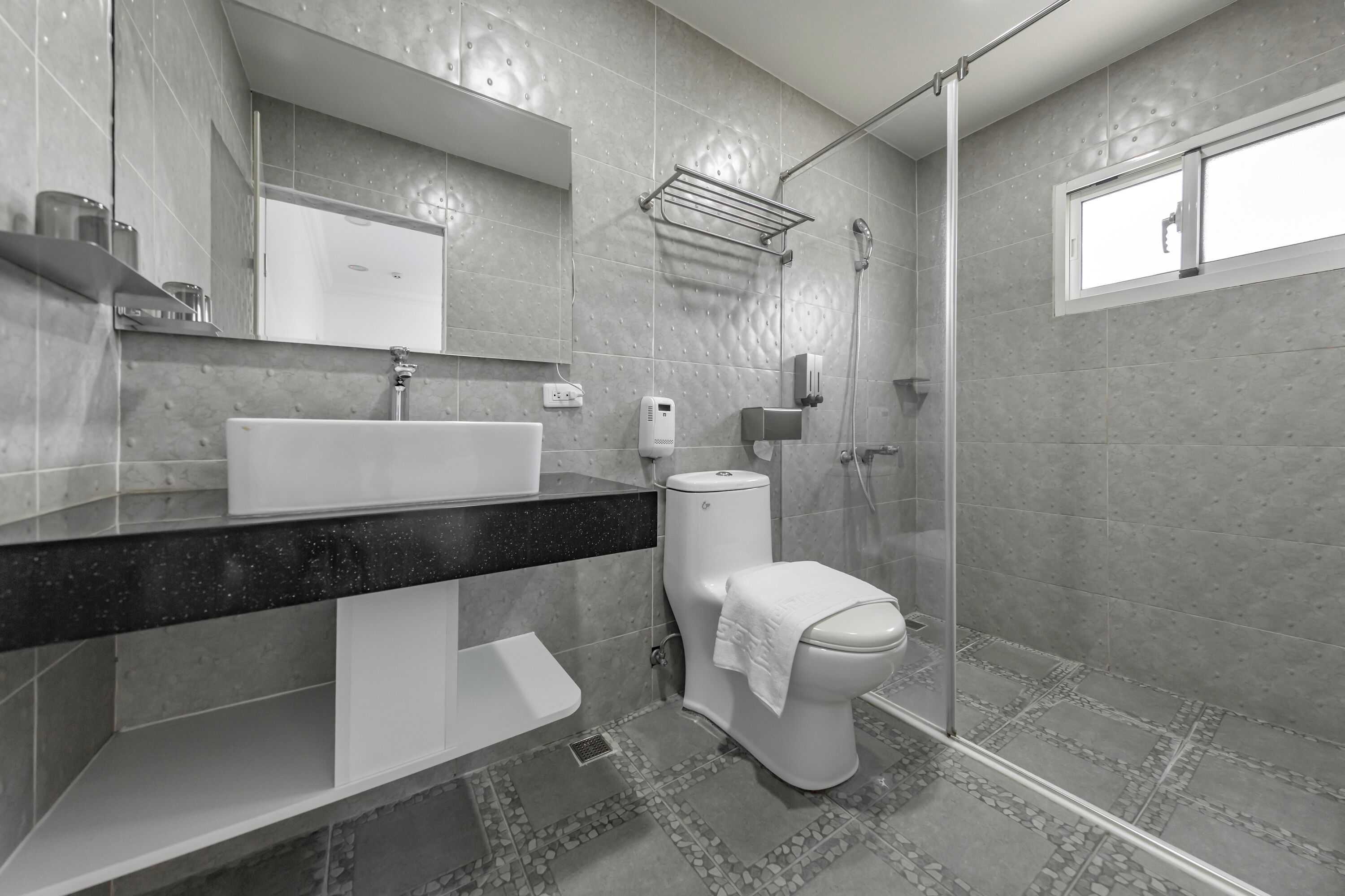 A modern bathroom with a large sink, toilet, and shower area.