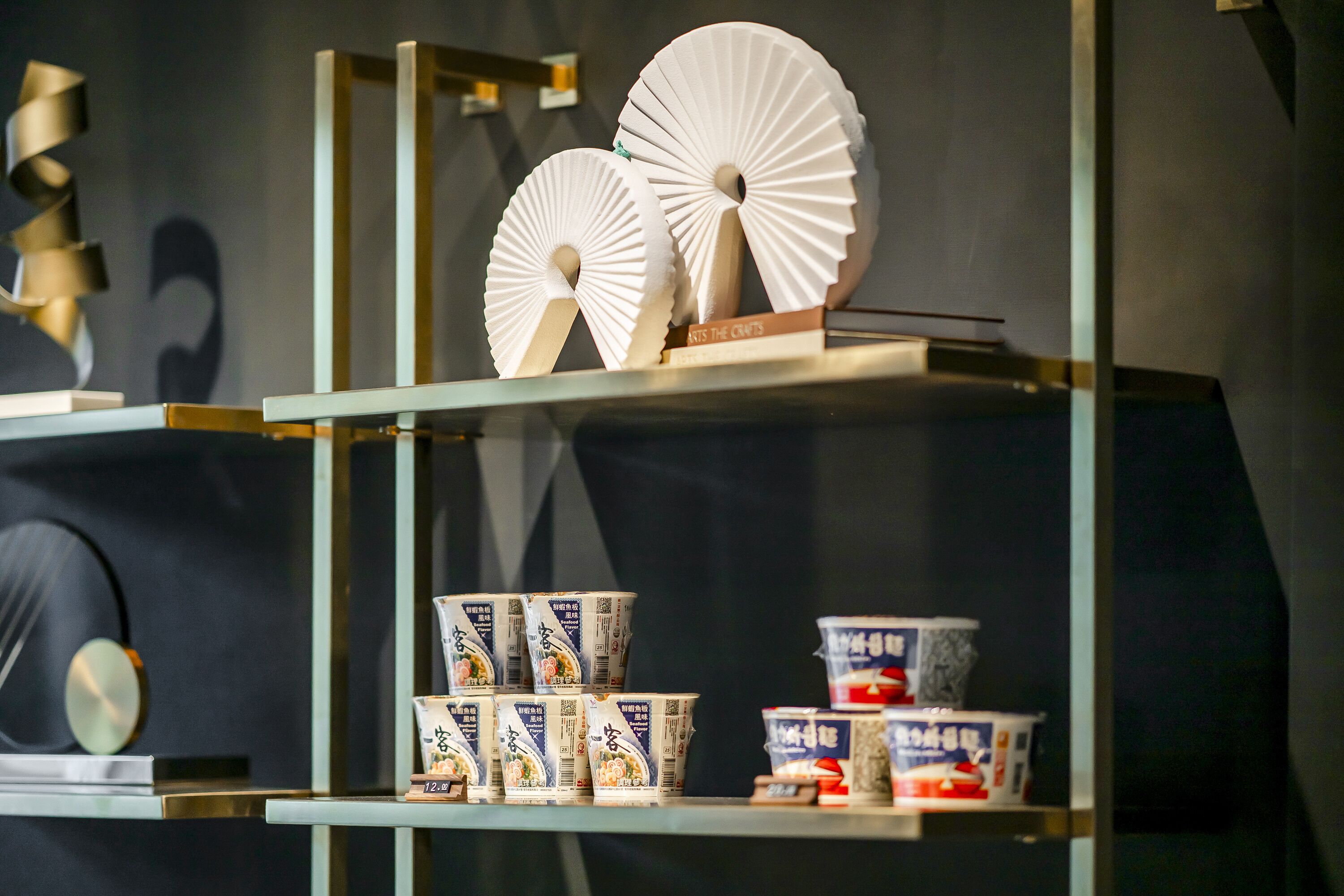 A display of fans and packaged food items on shelves.