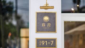 A hotel entrance with a sign indicating room number 91-7 and the name 'SUNSET MU'.