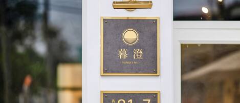 A hotel entrance with a sign indicating room number 91-7 and the name 'SUNSET MU'.