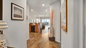 A modern kitchen with wooden cabinets, a dining area with chairs, and a large window offering a view.