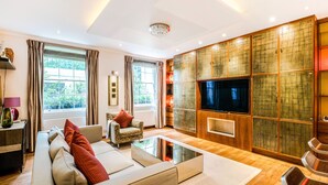 A modern living room with a sofa, armchairs, a coffee table, and a TV. - Central London Apartment, near Victoria Station (London)