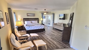 Une chambre d’hôtel équipée d’un lit, d’un canapé, d’une télévision et d’un fauteuil de massage.