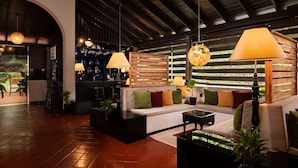 A modern lounge area with a sofa, coffee table, and hanging lamps. - EKHO Ella (Ella)