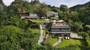 A modern hotel with multiple buildings surrounded by lush greenery and hills. - EKHO Ella (Ella)